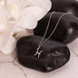 stainless steel pisces necklace displayed on top of 2 large stones