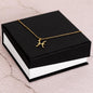 Gold Pisces Necklace laying on top of a standard box
